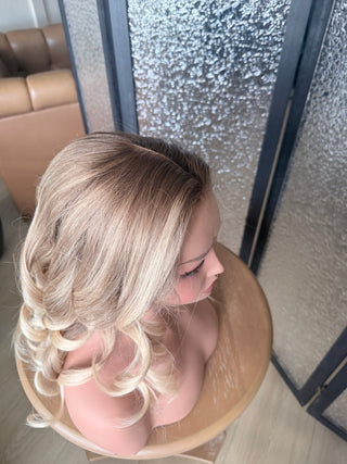 Natural parting on The Camille champagne blonde Remy human hair wig indoors top