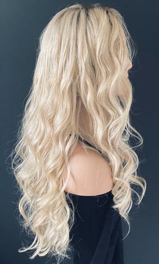 shows side profile view long blonde wig  with dimensional blonde color and soft curls added 